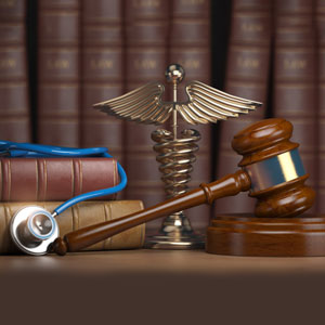 Gavel, stethoscope, and medical symbol in front of law books, representing VMA insights for injury attorneys - Evident Health